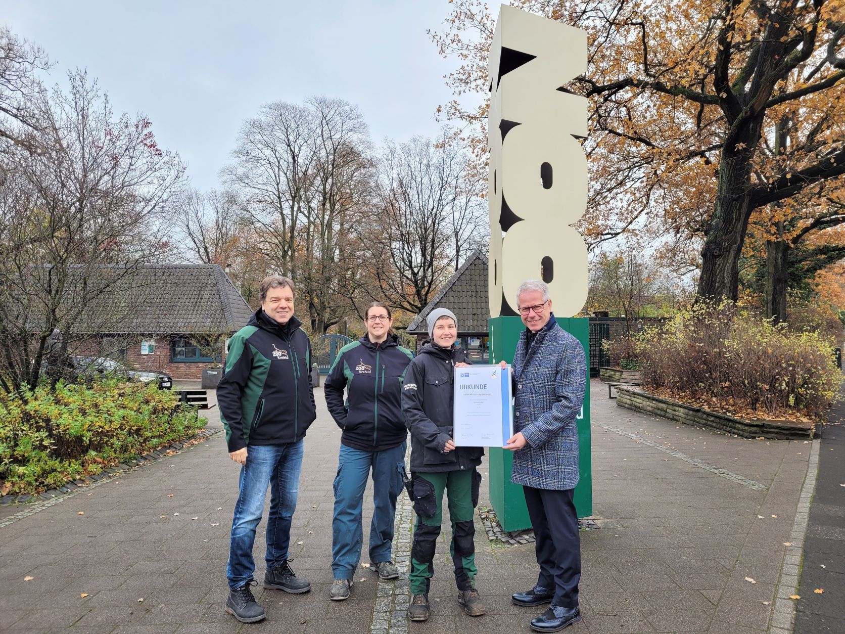 Vergabe der Auszeichnung des Zoo Krefeld für besonderen Leistungen in der Ausbildung (2.v.r.), der Landesbesten bei der Abschlussprüfung in der Zootierpflege. Ausbilderin Eva Ravagni (l.) und Zoodirektor Dr. Wolfgang Dreßen freuen sich über den doppelten Erfolg.